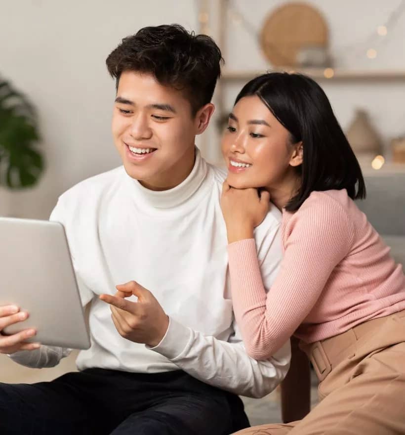 young-asian-spouses-relaxing-using-digital-tablet-browsing-internet-indoors.jpg